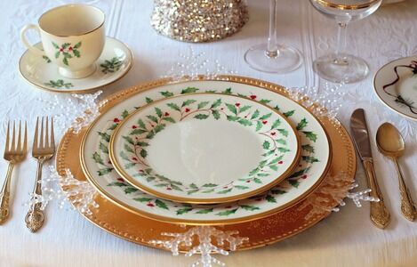 Christmas Dinner planning tips - table set for formal meal with Christmas patterned dinnerware