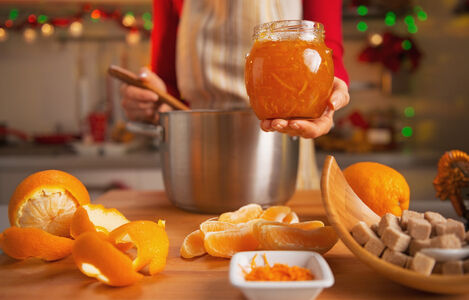 Closeup,On,Young,Housewife,Making,Orange,Jam,In,Christmas,Decorated