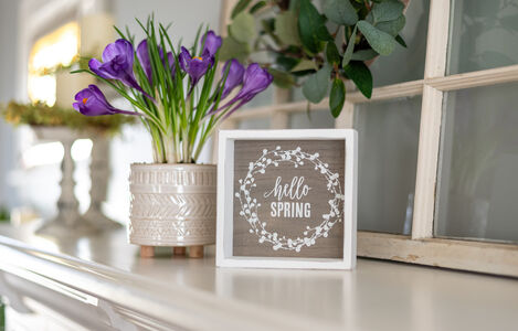 Hello,Spring,Sign,With,Purple,Flowers,On,The,Mantel